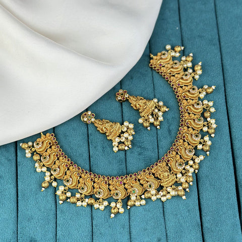 Gold necklace and earrings on a blue fabric background