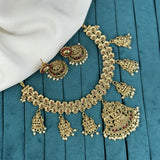 Gold jewelry set with necklace and earrings on a blue fabric background