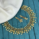 Gold necklace with pearls and gemstones on a blue fabric background