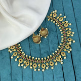 Gold necklace and earrings on a blue fabric background