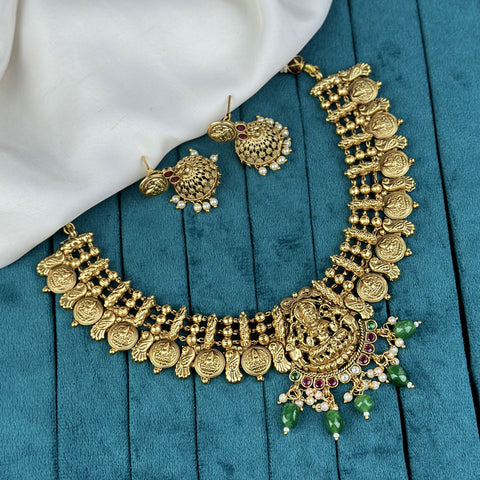 Gold necklace and earrings on a blue fabric background