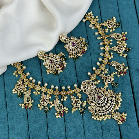 Ornate gold necklace and earrings on a blue fabric background