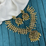 Ornate gold necklace and earrings on a blue fabric background