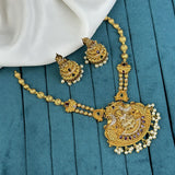 Gold necklace and earrings set on a blue fabric background
