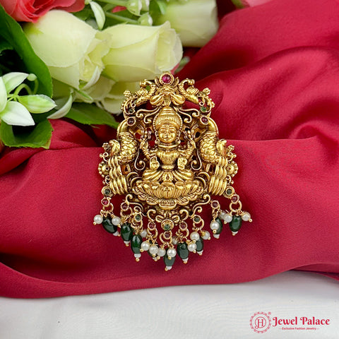 Decorative gold pendant with green stones on a red fabric background, featuring the Jewel Palace logo.