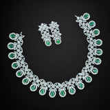 Jewelry set with necklace and earrings featuring green gemstones on a black background