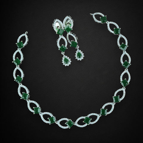 Jewelry set with necklace and earrings featuring green gemstones on a black background