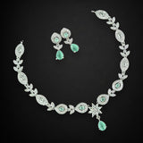 Jewelry set with necklace and earrings featuring green gemstones on a black background