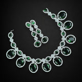 Jewelry set with necklace and earrings featuring green gemstones on a black background