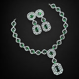 Jewelry set with necklace and earrings featuring green gemstones on a black background