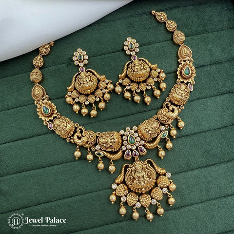 Gold necklace and earrings set on a green fabric background with 'Jewel Palace' branding.