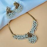 Pearl necklace and earrings on a beige surface with a blue fabric background