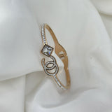 Gold bracelet with a diamond on a white fabric background