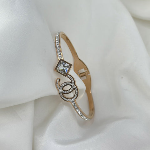Gold bracelet with a diamond on a white fabric background