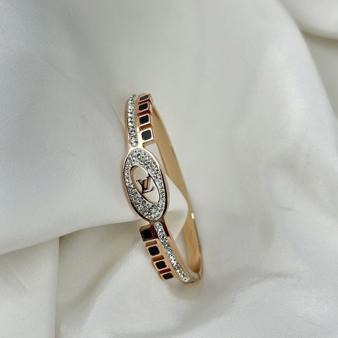 Rose gold bracelet with diamond accents on a white fabric background