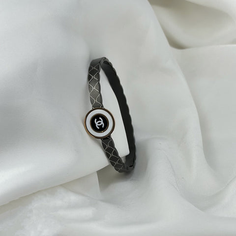 Bracelet with a Chanel logo on a white fabric background