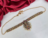 Decorative headband with intricate design on a white surface with red fabric in the background