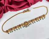 Decorative gold necklace with gemstones on a white background