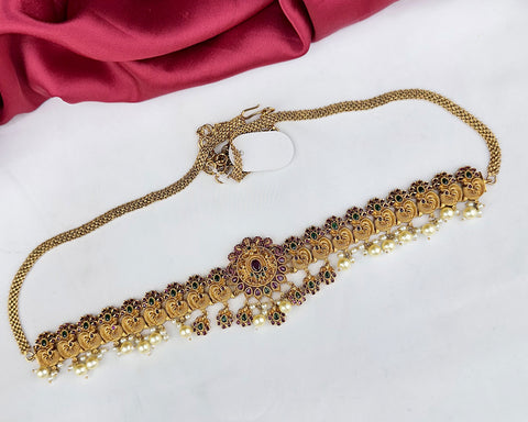 Gold necklace with intricate designs on a white background