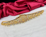 Gold decorative belt with pearls on a red fabric background
