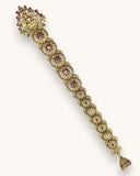 Gold bracelet with floral design and gemstones on a white background