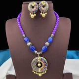 Jewelry set with necklace and earrings on a brown stand