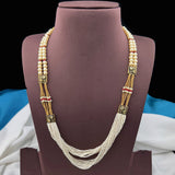 Pearl necklace with gold accents on a brown velvet stand