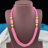Pink beaded necklace with gold accents on a brown mannequin bust.