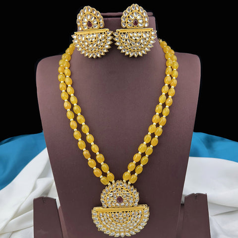 Gold necklace and earrings on a mannequin with a blue and white fabric background