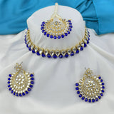 Jewelry set with blue stones and gold accents on a white and blue fabric background