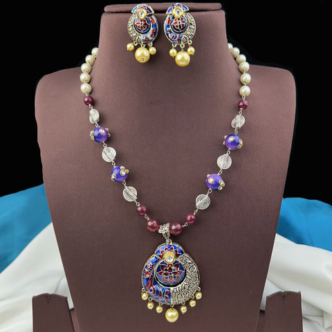 Jewelry set with necklace and earrings on a brown stand