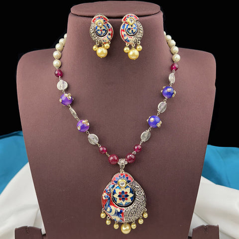 Jewelry set with necklace and earrings on a brown stand