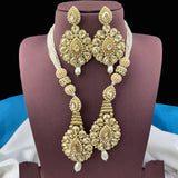 Gold necklace and earrings set on a mannequin bust with a dark background