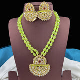 Green beaded necklace with gold and red accents on a mannequin bust.