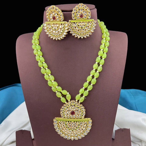 Green beaded necklace with gold and red accents on a mannequin bust.