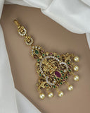 Gold necklace with pearls and gemstones on a white fabric background