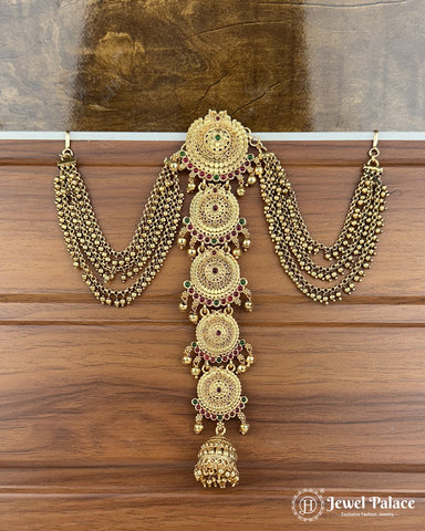 Ornate gold necklace with intricate designs on a wooden surface, branded 'Jewel Palace'.