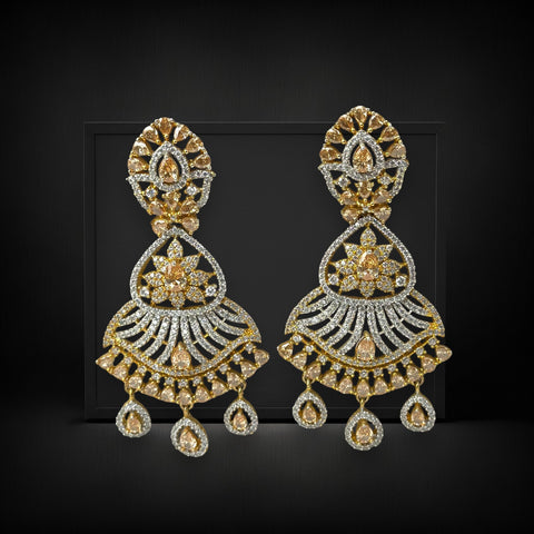 Pair of gold and silver earrings on a black background