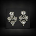Pair of silver chandelier earrings on a black background