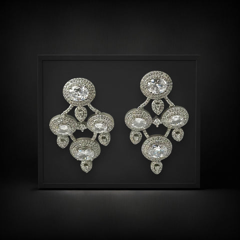 Pair of silver chandelier earrings on a black background