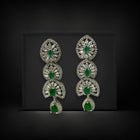 Pair of silver earrings with green gemstones on a black background