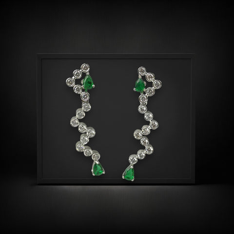 Pair of earrings with green gemstones and clear stones on a black background