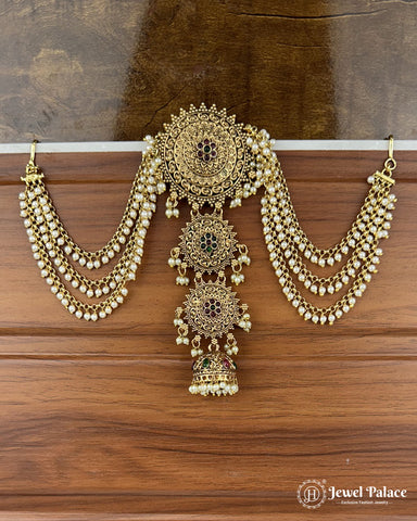 Ornate gold necklace with hanging pendants on a wooden surface, brand 'Jewel Palace' visible.