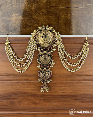 Ornate gold necklace with intricate designs on a wooden surface, branded 'Jewel Palace'.