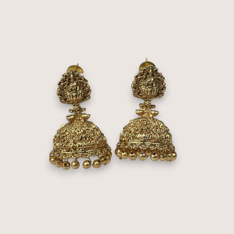 Pair of gold earrings on a light beige background