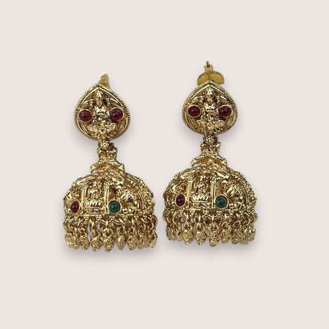 Pair of gold earrings with red and green gemstones on a white background