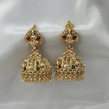 Gold earrings with red and green gemstones on a white background
