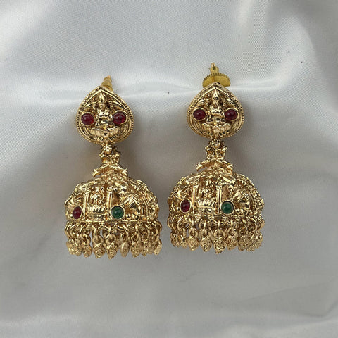 Gold earrings with red and green gemstones on a white background