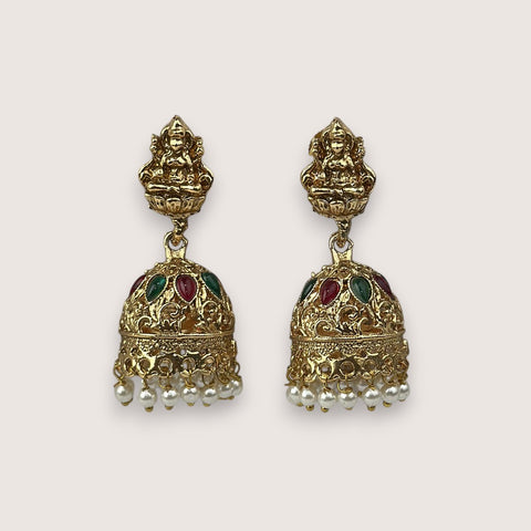 Gold earrings with intricate designs and small pearls on a light gray background