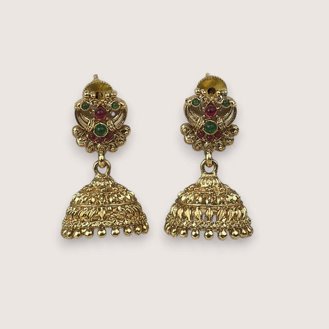 Gold earrings with gemstones on a light gray background